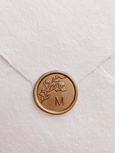 Floral silhouette monogram wax seal in gold on handmade paper envelope