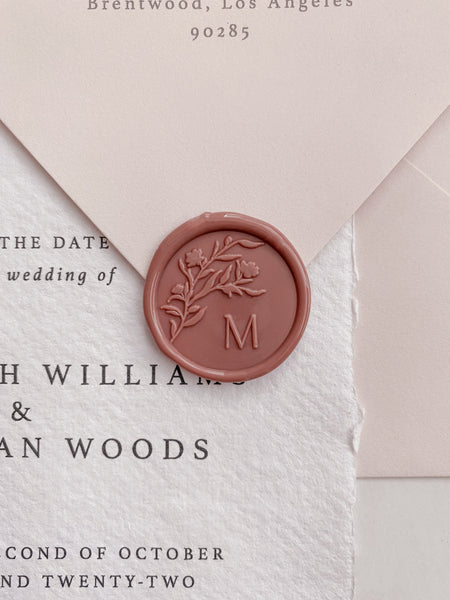 Floral silhouette single initial wax seal in dusty rose on white handmade paper invitation and pale blush envelope