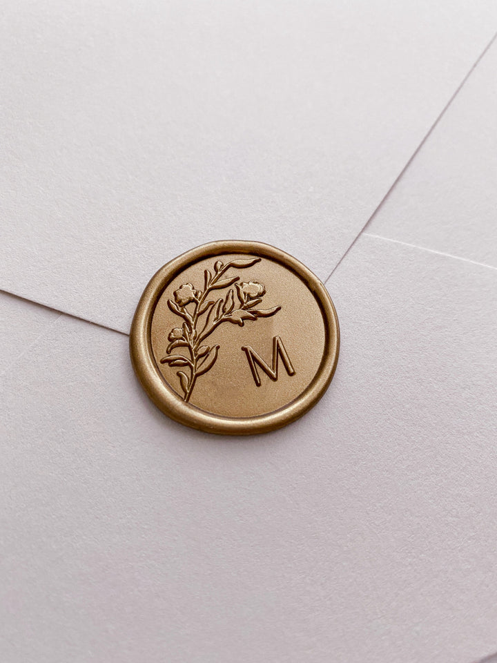 Floral silhouette single initial gold custom wax seal on beige paper envelope