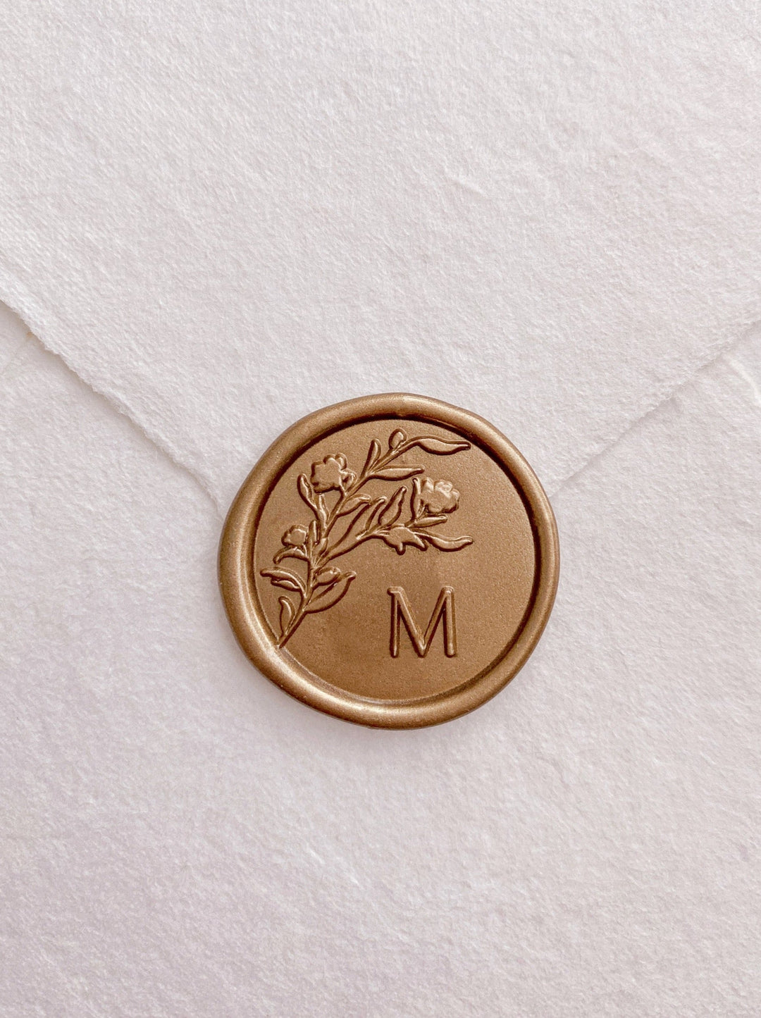 Floral silhouette single gold custom initial wax seal on beige handmade paper envelope
