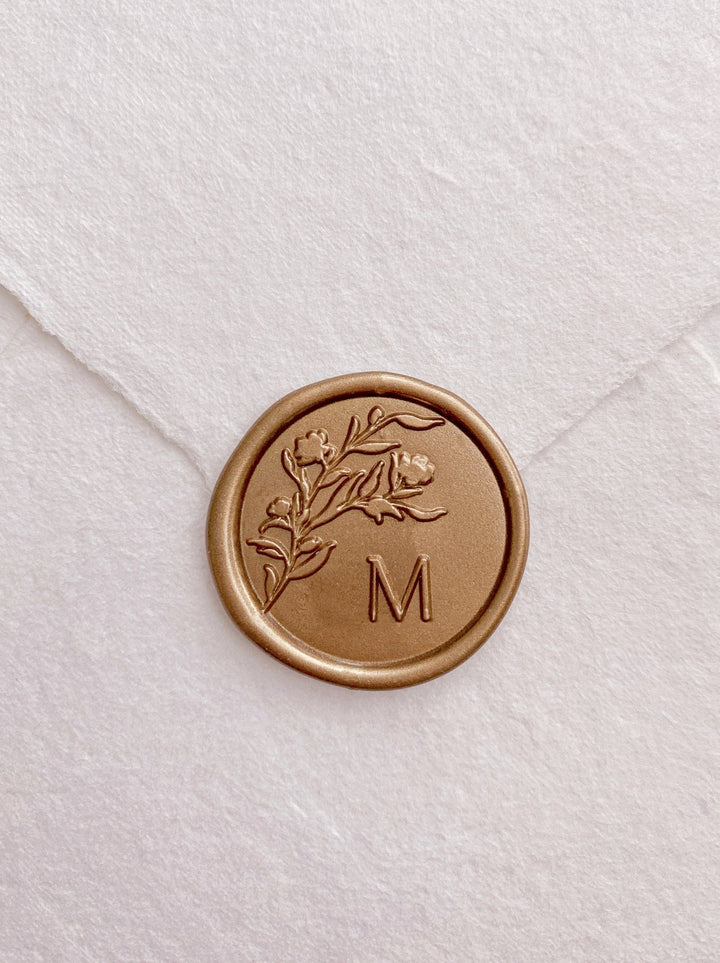 Floral silhouette single gold custom initial wax seal on beige handmade paper envelope