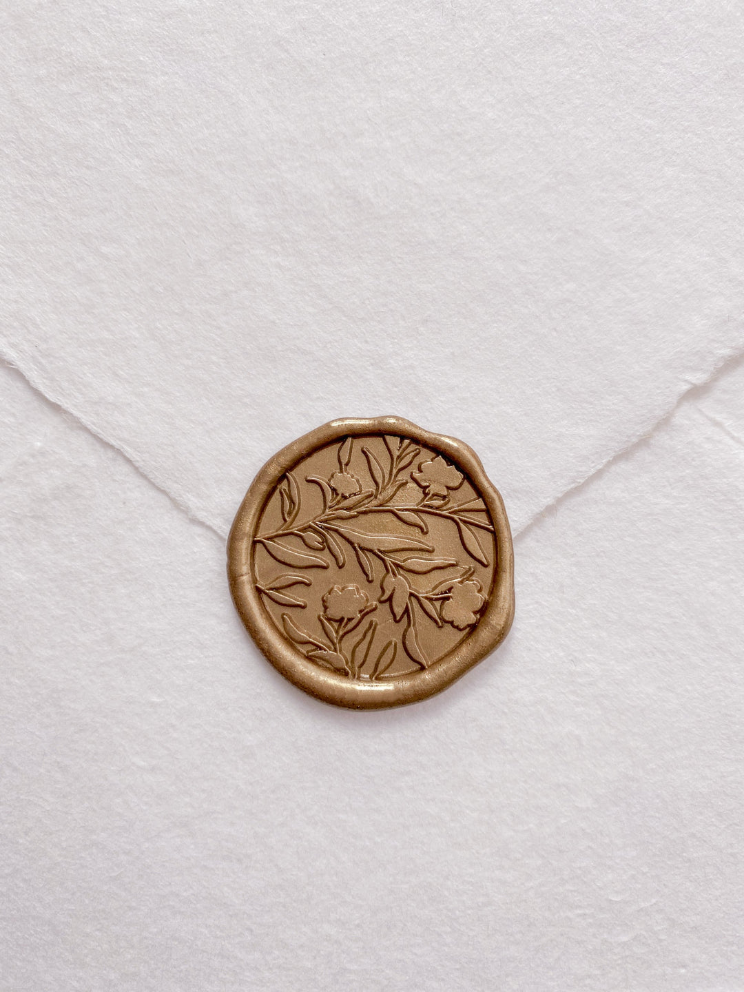 Floral silhouette wax seal in gold on white handmade paper envelope_front angle 