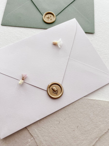 mini flower emoji gold wax seal on light beige envelope 