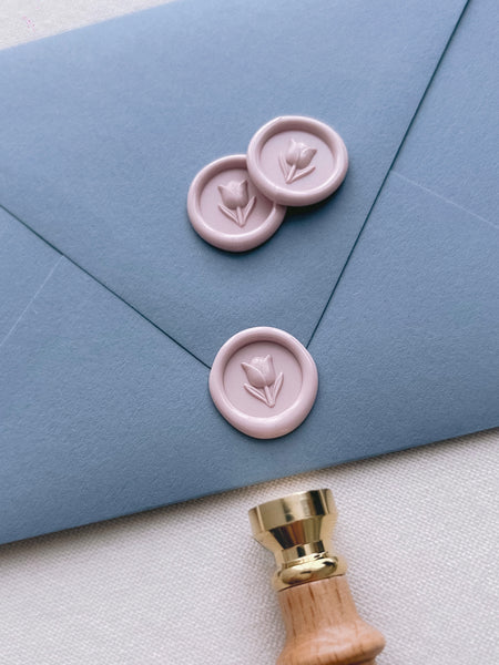light pink flower emoji mini wax seals on a dusty blue envelope
