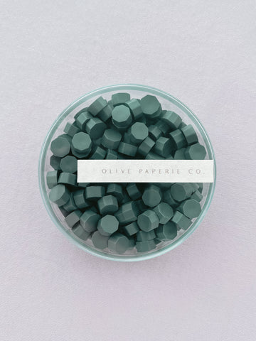 non-metallic pine green sealing wax beads in a clear round box