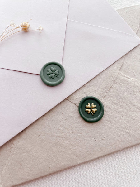 four leaf clover mini green wax seals on white and beige envelopes