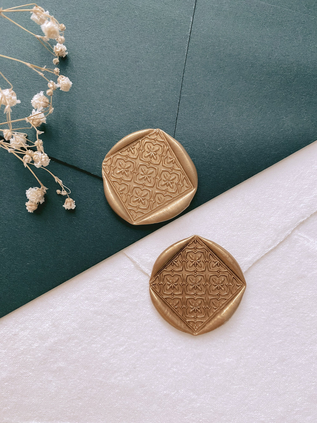 Moroccan tile pattern square shaped wax seals in gold_front angle on dark green and white envelopes