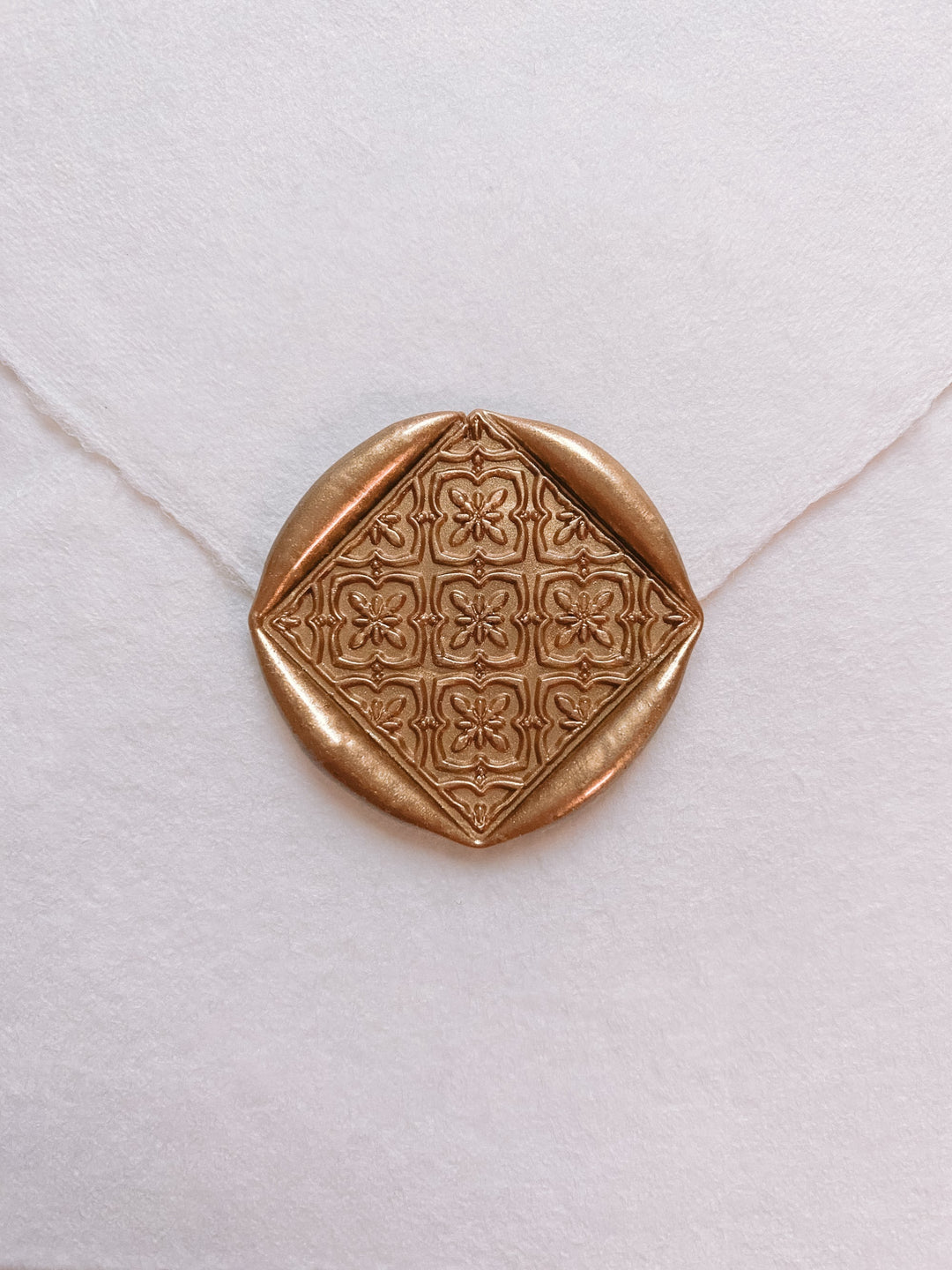 Moroccan tile pattern diamond shaped wax seal in gold_front angle