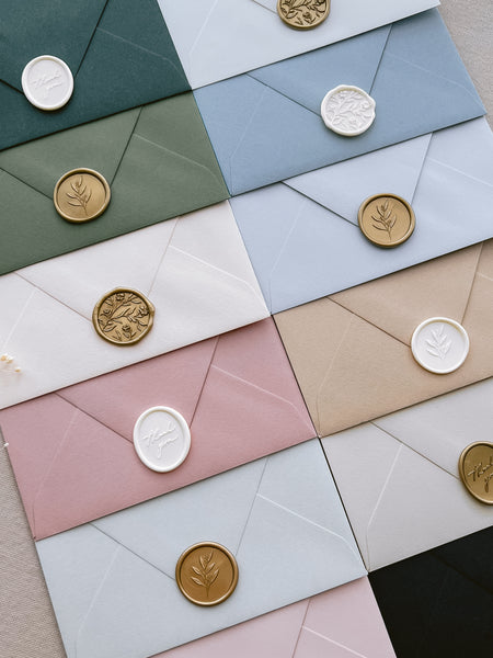 gold and white wax seals on envelopes in various colors