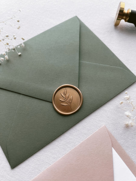 leaf branch gold wax seal on olive green envelope