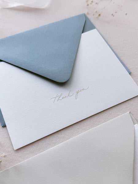 gold foil embossed thank you card and dusty blue envelope 