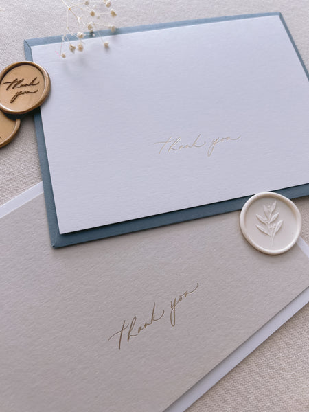 beige and white gold foil pressed thank you cards with white and gold wax seals