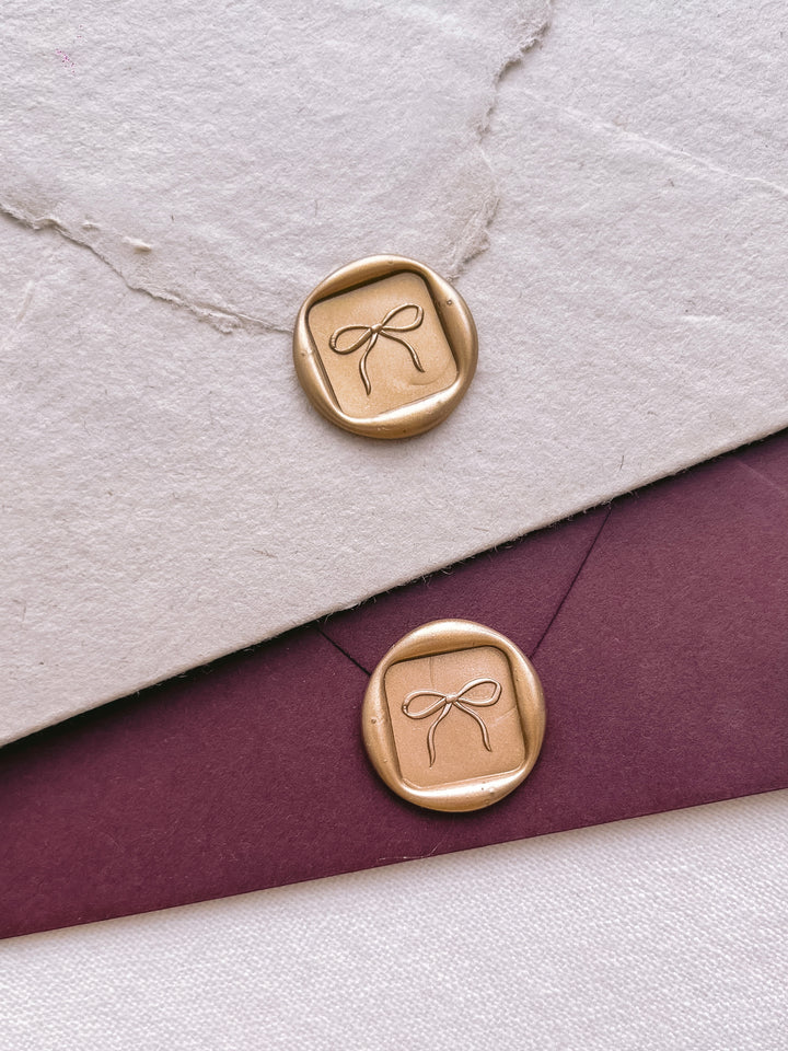 square shaped hand-drawn bow gold wax seals