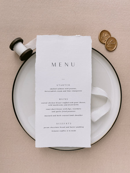 Handmade paper menu with natural deckled edges on table setting in design 4 with white silk ribbon and Olive Paperie Co. wax seals in gold as decoration