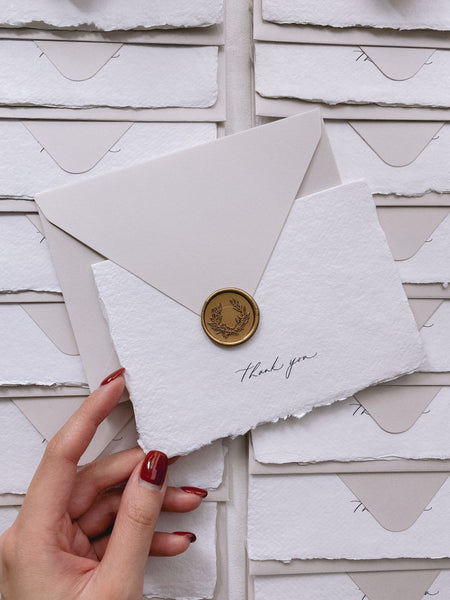 Handmade paper thank you cards with wreath wax seal in gold on light gray paper envelope_front angle