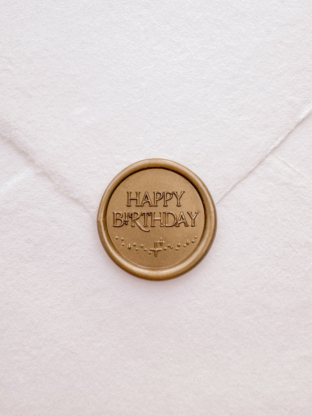 Gold Happy Birthday wax seal on a white deckled edge handmade paper envelope