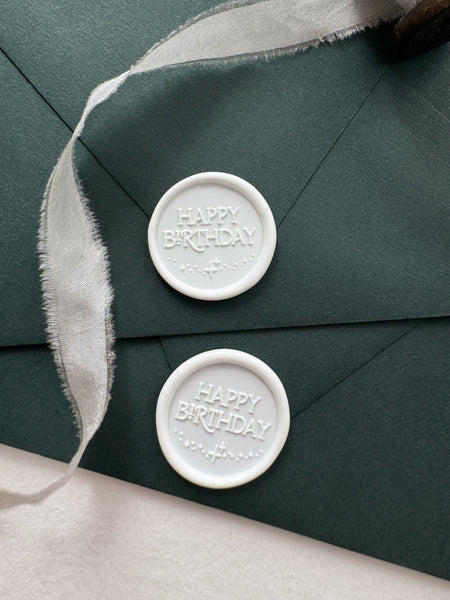 White Happy Birthday wax seals on dark green envelopes style with a strand of white silk ribbon