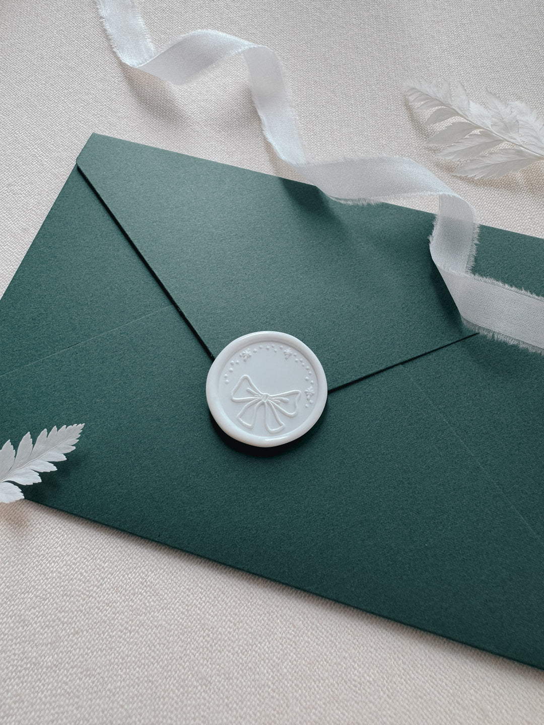 white festive bow wax seal on Christmas card envelope
