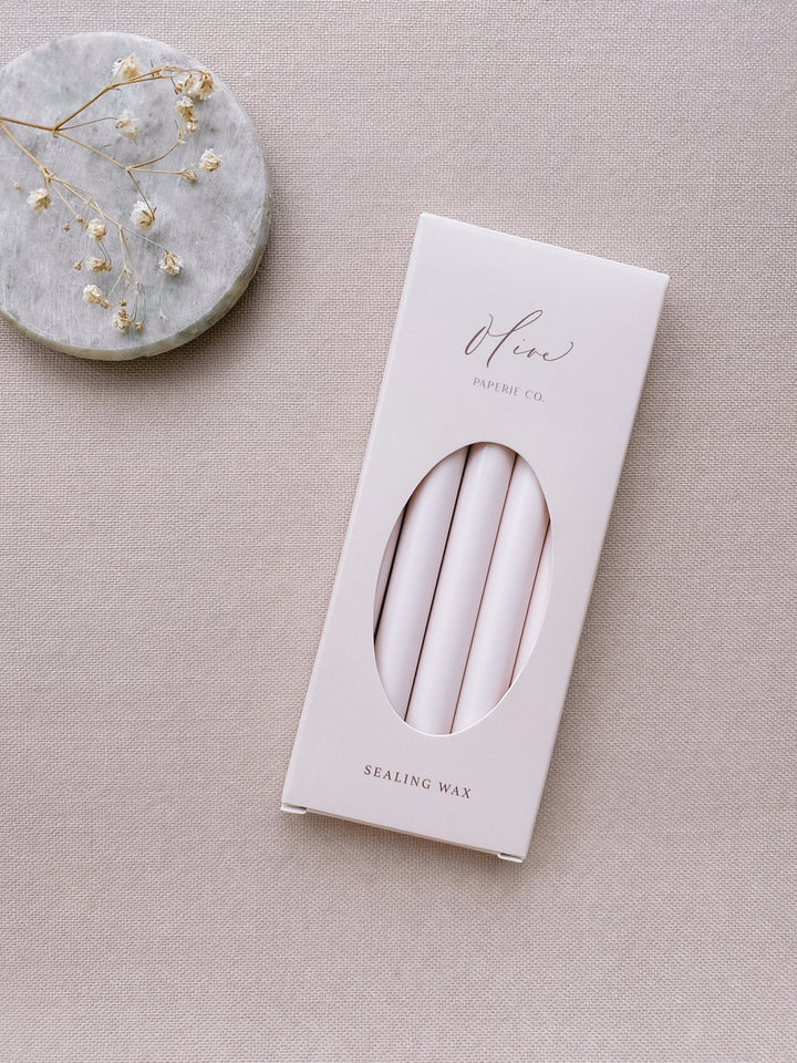 a box of 5 glue gun sealing wax sticks in ivory nude color styled with small gray stone dish and dried flowers 