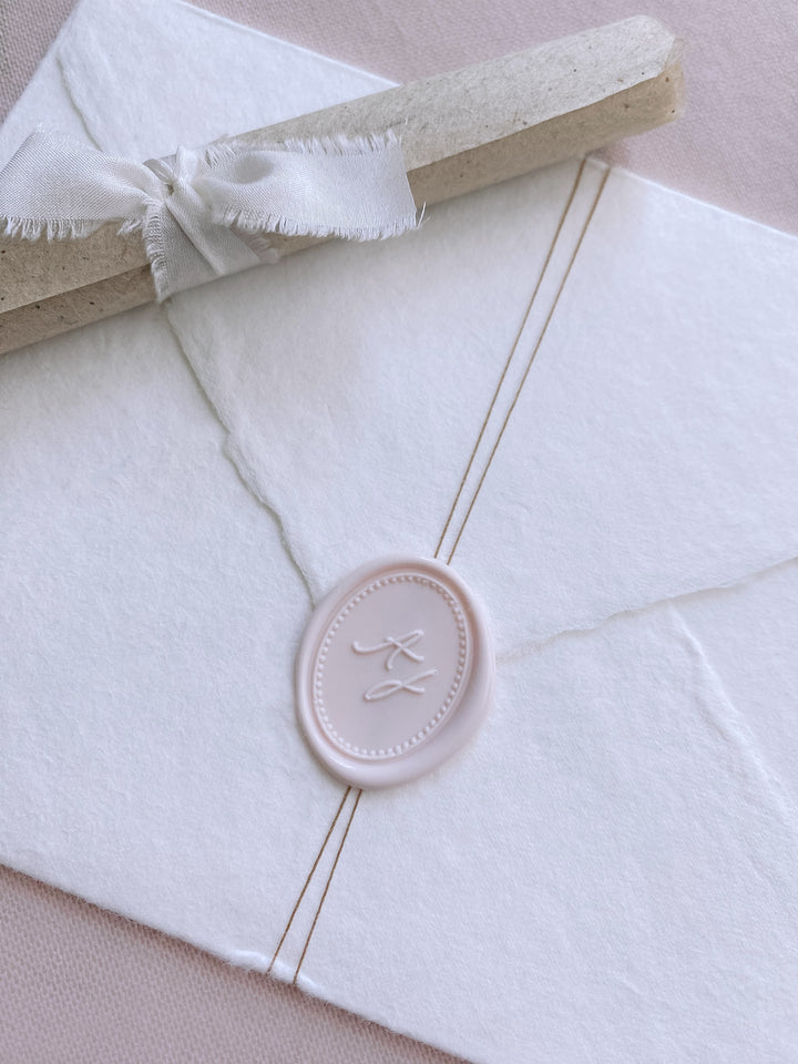 Oval monogram custom wax seal ivory nude color on beige handmade paper envelope wrapped with fine twine