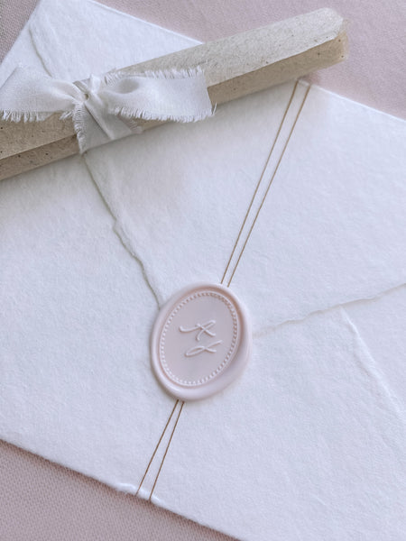 Oval monogram custom wax seal ivory nude color on beige handmade paper envelope wrapped with fine twine