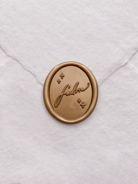 Gold J'adore oval wax seal on white handmade paper envelope