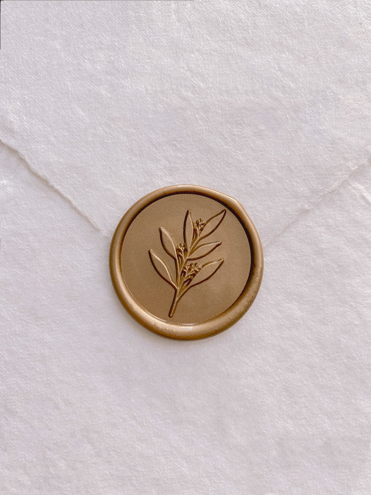 Gold leaf branch wax seal on white handmade paper envelope