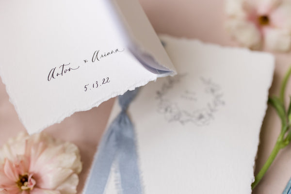 Personalized names in calligraphy on the inner cover of set of letterpress floral wreath vow books