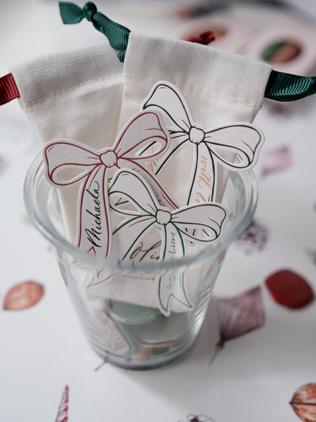 Decorative die-cut bow gift tags in green, red and black with text Merry Christmas and Happy Holidays 