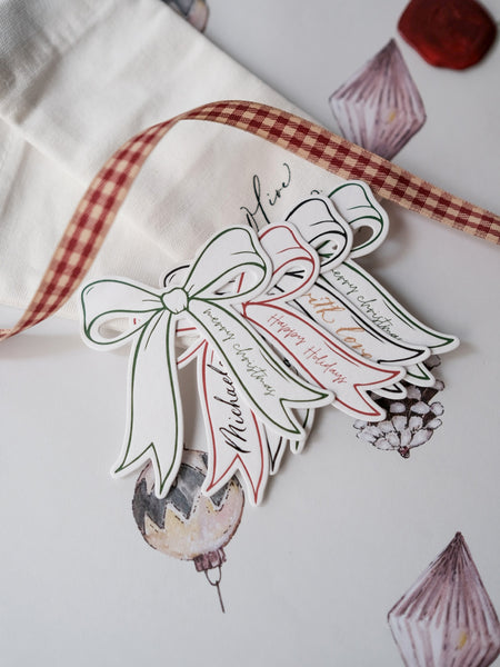 Decorative die-cut bow gift tags in green, red and black with text Merry Christmas and Happy Holidays 