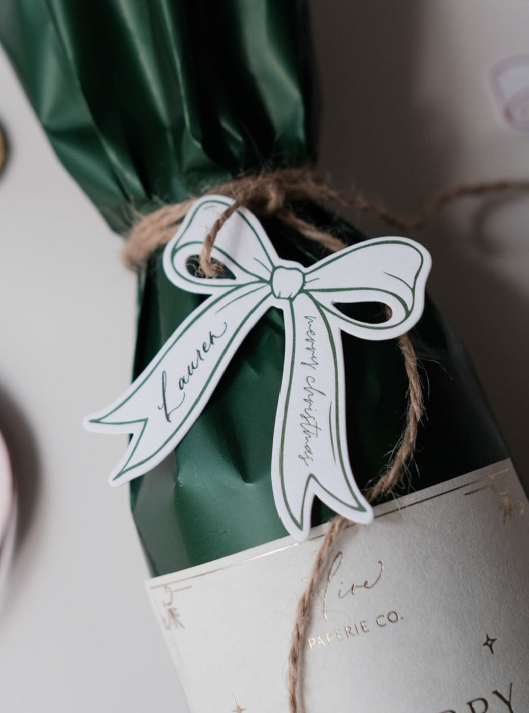 Letterpress die-cut bow gift tag on a holiday gift with &