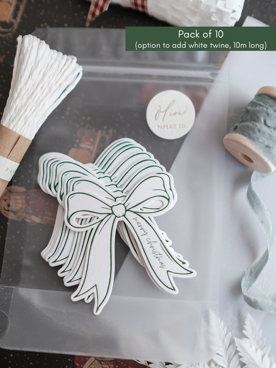 Stack of green Merry Christmas gift tags with white twine
