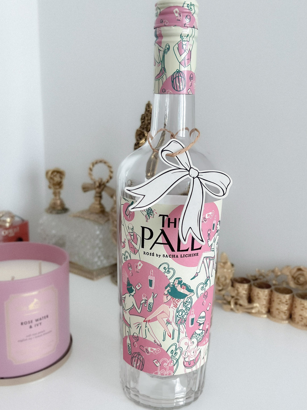 Black die-cut bow shaped gift tag hanging on a wine bottle