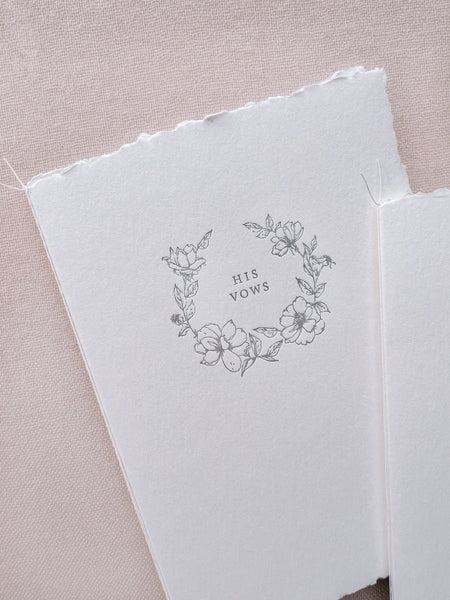 A set of two His and Her letterpress floral wreath vow books with fine white twine