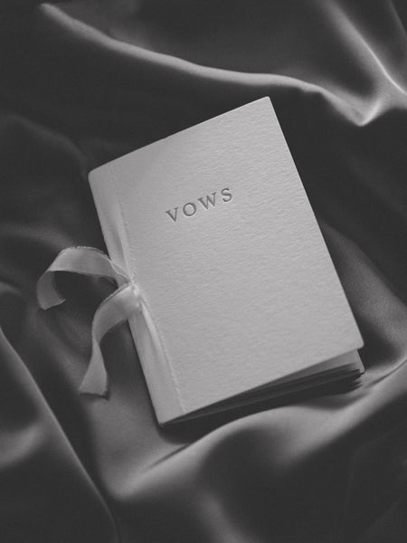 letterpress white vow book tied with white silk ribbon