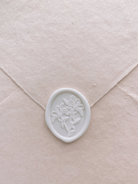 Oval lily floral white wax seal on handmade paper envelope