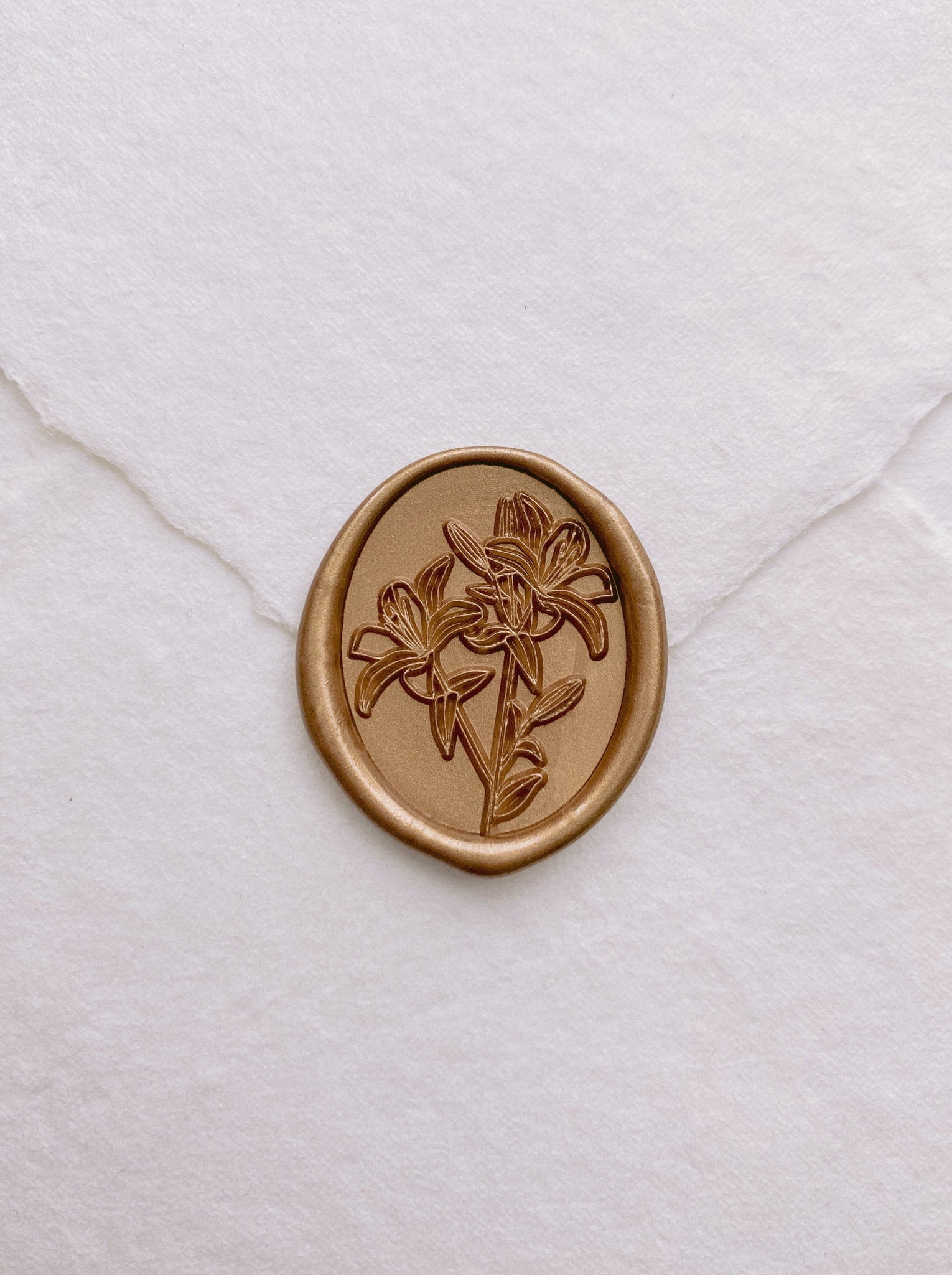 Oval lily floral wax seal in gold on handmade paper envelope_front angle