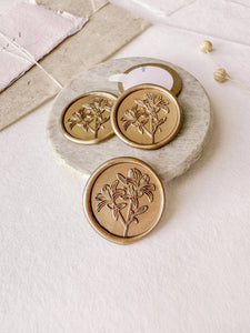 Lilies floral gold wax seals styled with a small gray stone dish, handmade paper and a dried floral branch