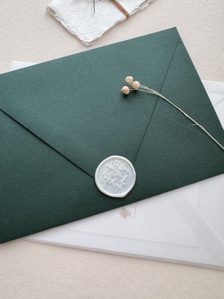 Lily floral wax seal in color white pearl on a dark green envelope