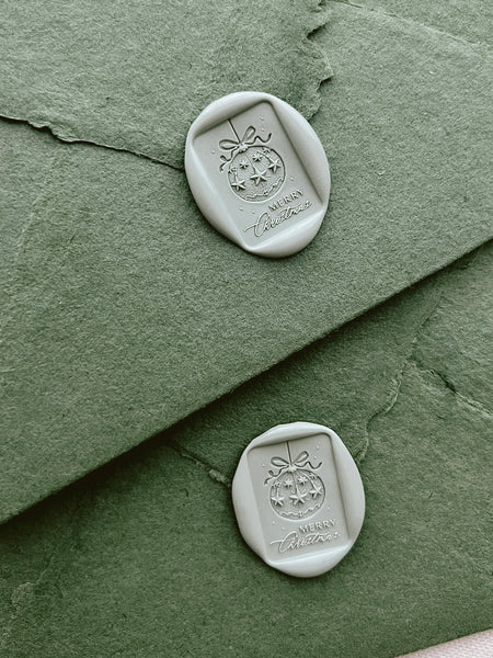 Light sage green Merry Christmas ornament rectangular wax seals on green textured Christmas card envelopes