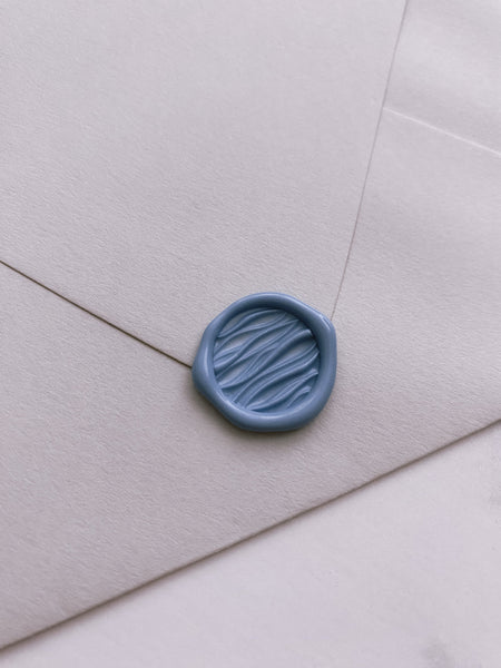 Mini 3D ocean waves wax seal in dusty blue on paper envelope_side angle