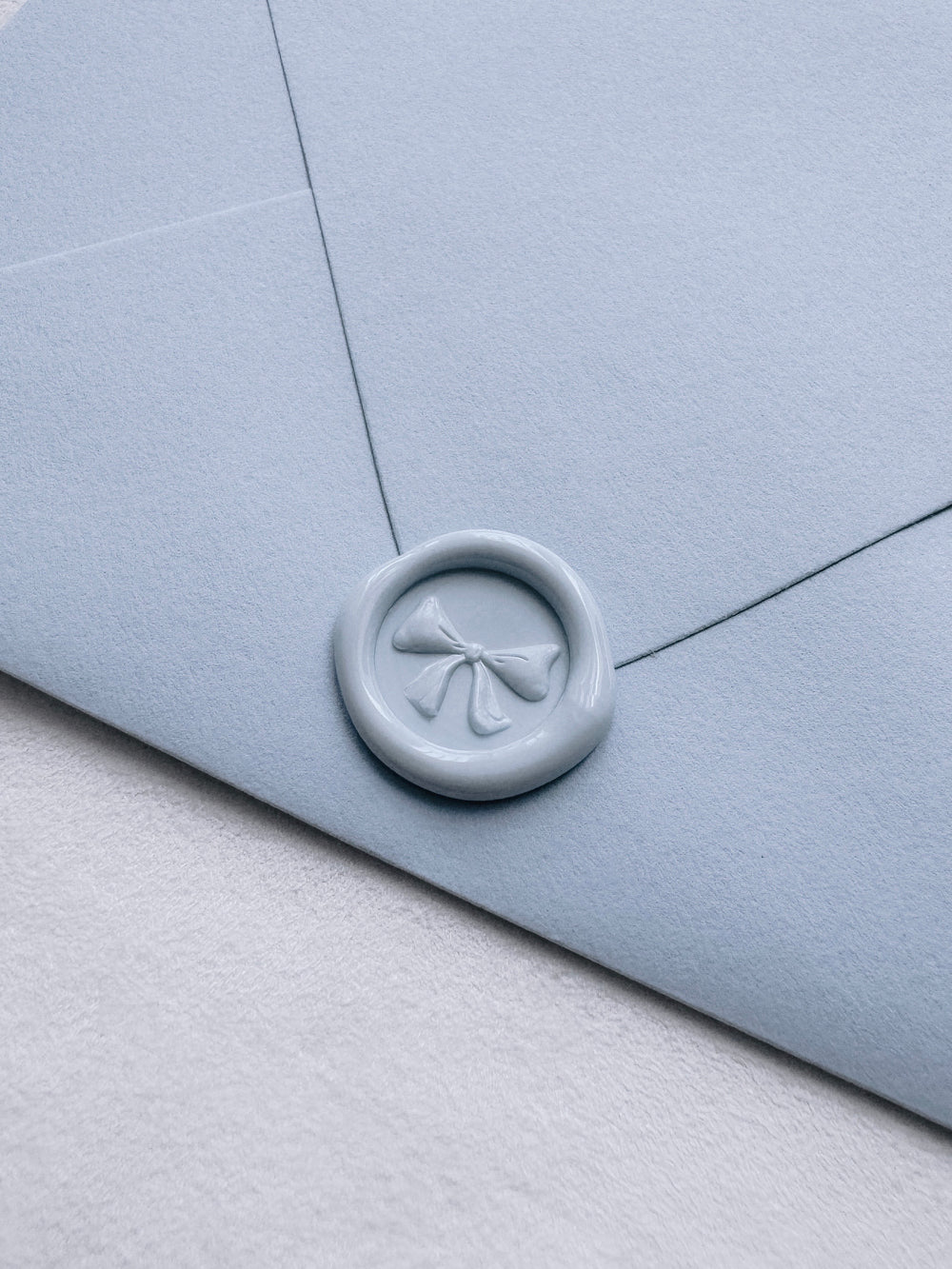light blue 3D ribbon bow mini wax seal on a light blue envelope