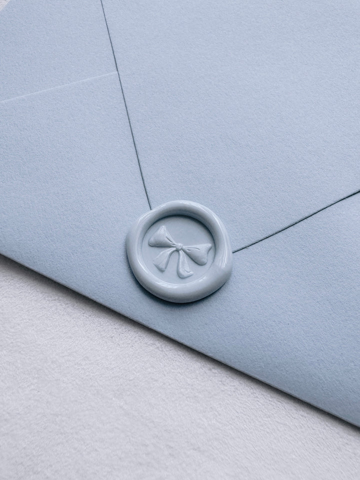 light blue 3D ribbon bow mini wax seal on a light blue envelope
