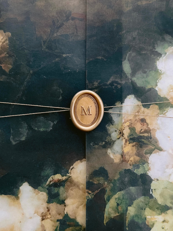 Personalized initial mini gold wax seal featuring a custom monogram with a simple border design on a dark floral wedding invitation vellum jacket 