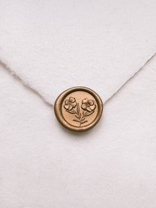 Mini gold wax seal featuring gardenia flowers with 3D engravings on a white handmade paper envelope