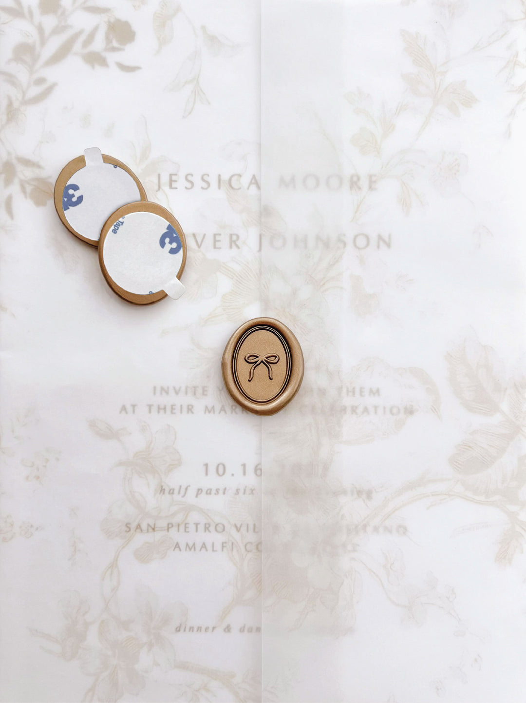 mini handdrawn bow oval gold wax seal stickers with self-adhesive backings on a beige floral vellum jacket