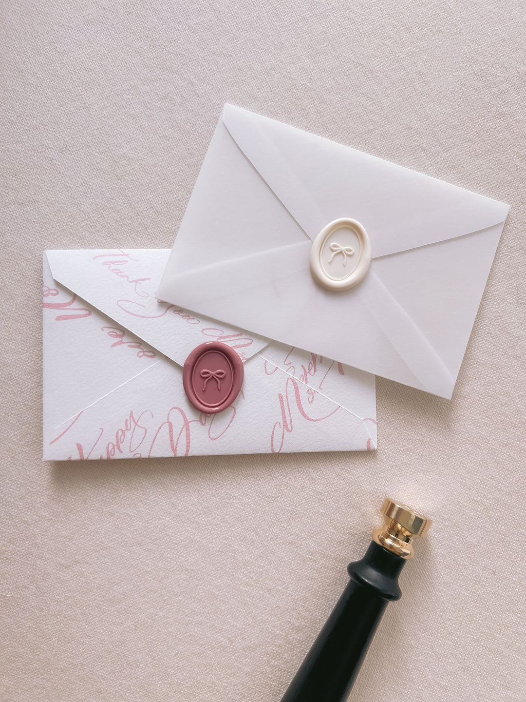 off-white and rose pink mini ribbon bow oval wax seals on a white and pink mini envelopes 