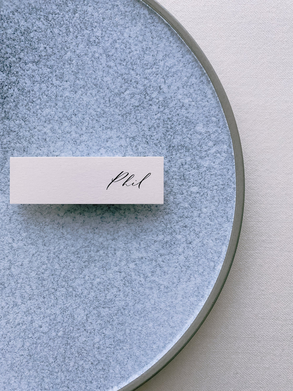 slim place card in light blush color hand lettered in modern calligraphy in black ink