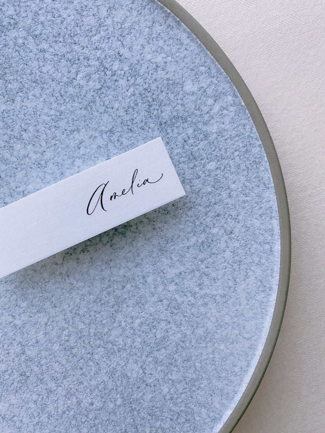 slim place card in white color hand lettered in modern calligraphy in black ink
