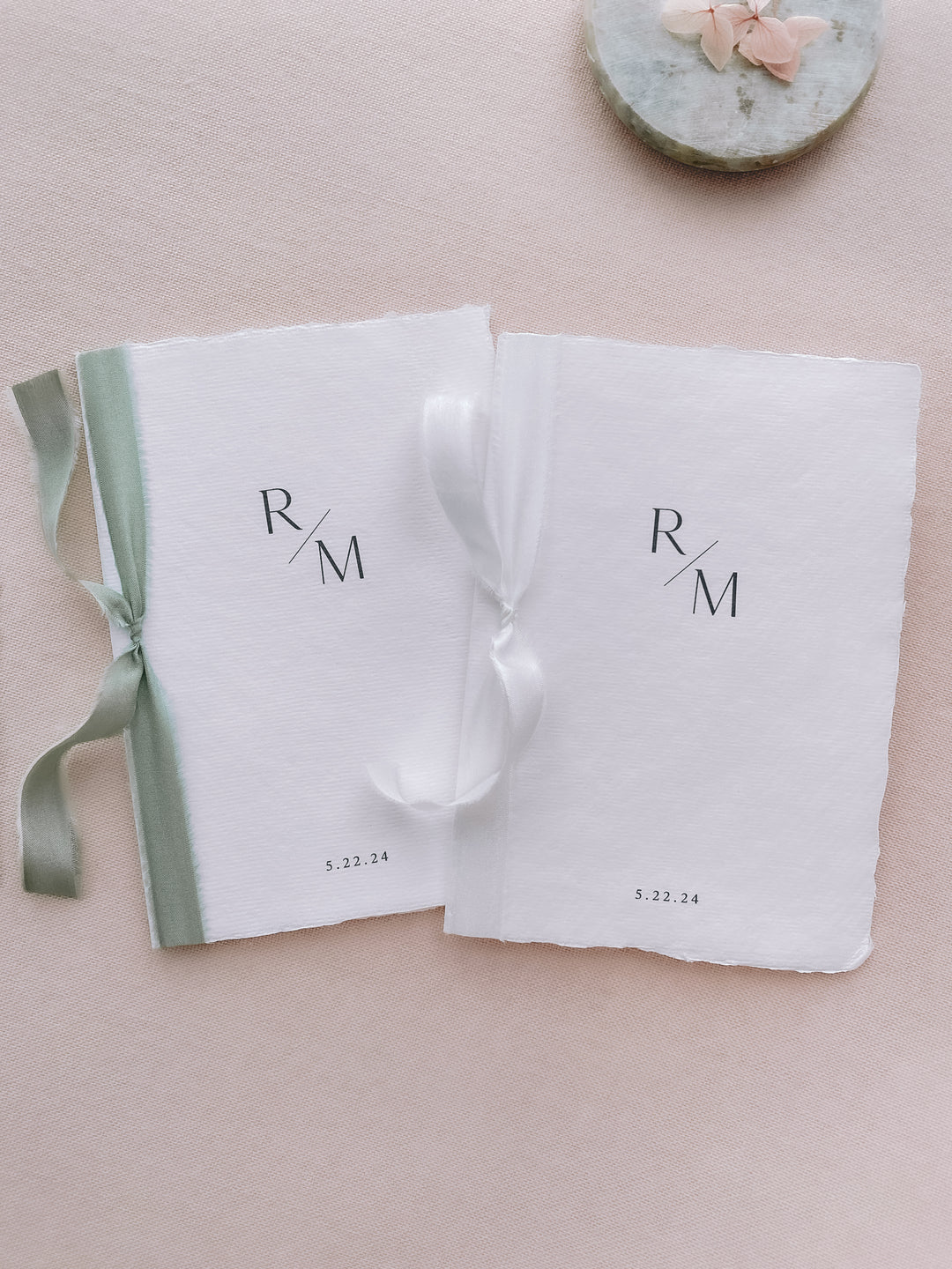 personalized monogram white handmade paper wedding vow books tied in sage green and white silk ribbons